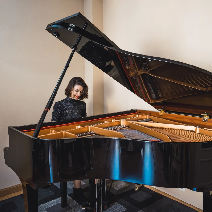 Young woman playing a grand piano